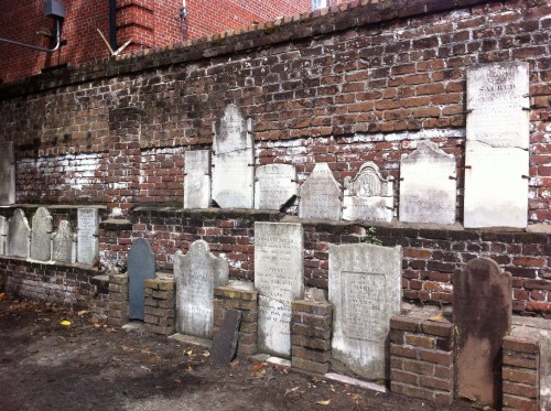 A wall filled with old headstones. 